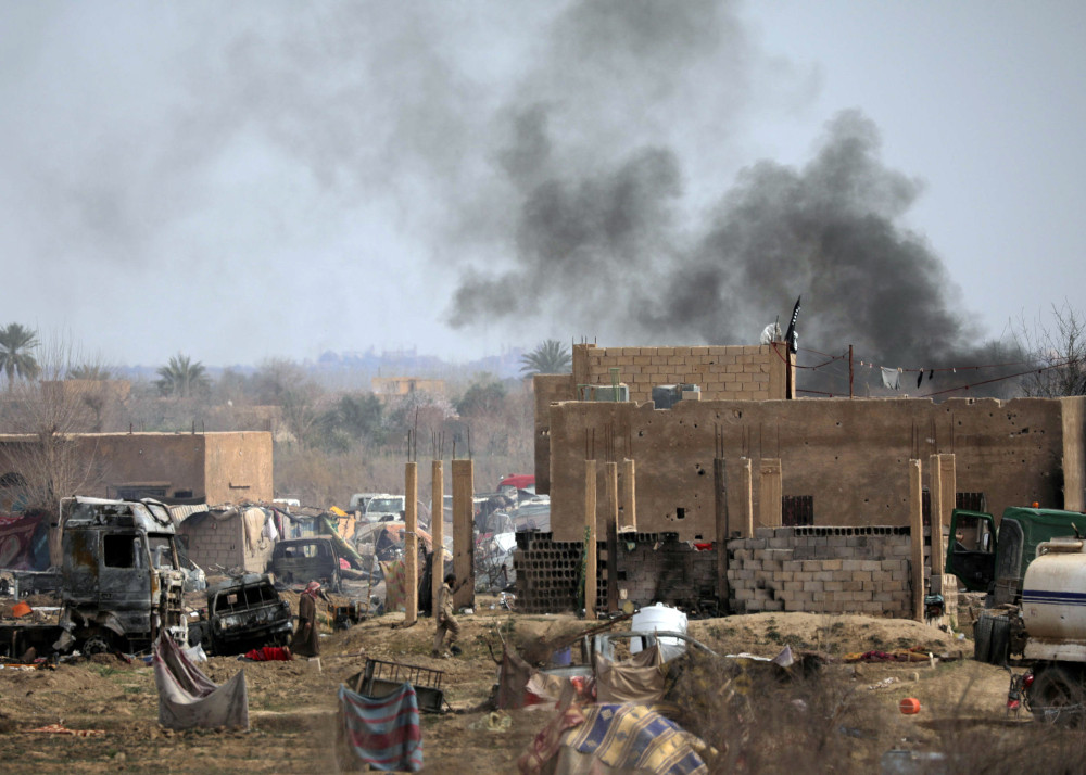 Islamic State members walk in the last besieged neighbourhood in the village of Baghouz, Deir Al Zor province, Syria March 10, 2019. u00e2u20acu201d Reuters pic  